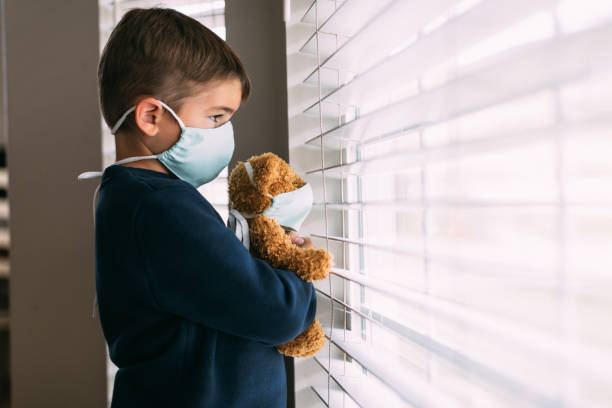 istock Young Boy and his Teddy Wearing Face Masks 1217057303