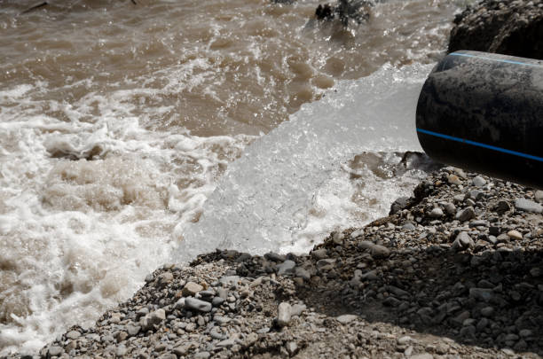 istock a strong stream of water pouring from a plastic water pipe into a river 1217063329