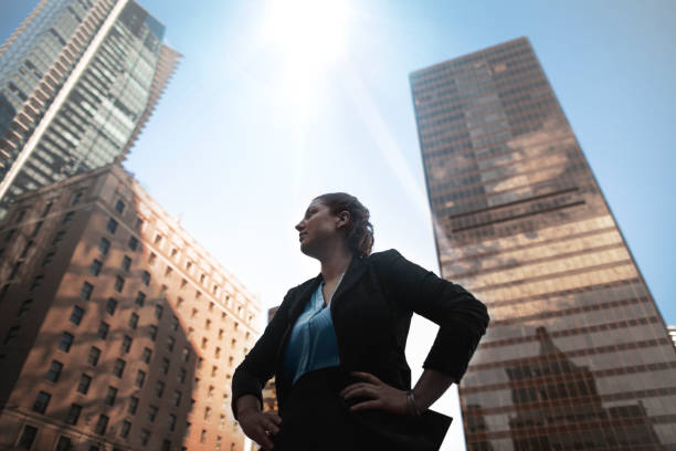 Low angle view of Caucasian businesswoman looking away at downtown cityscape Low angle view of Caucasian businesswoman looking away at downtown cityscape oracle building stock pictures, royalty-free photos & images