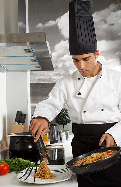 istock Chef Serving some Noddles in a Plate from a Friying Pan 121706614