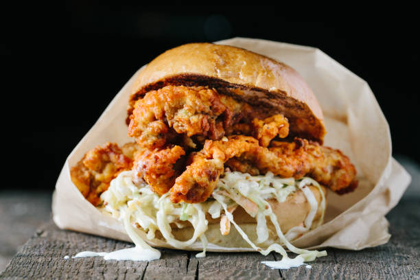 Juicy fried chichen sandwich on a wooden surface