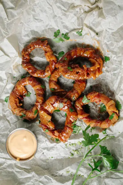 Crispy deep-fried onion rings on parchment paper
