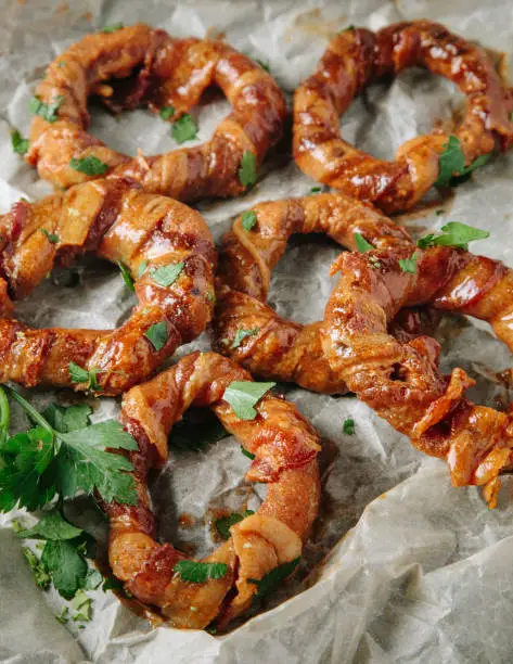 Bacon wrapped onion rings on parchment paper
