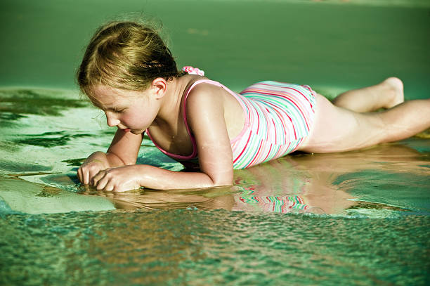 cute little girl with a pony tail playing with dirt