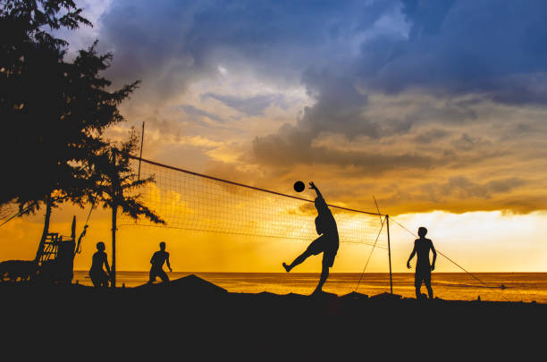 силуэт пляжного волейболиста на пляже - volleying sport summer men стоковые фото и изображения
