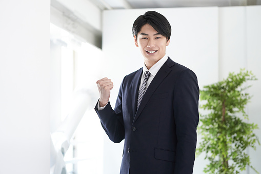 A Japanese male businessman poses for a camera gaze.