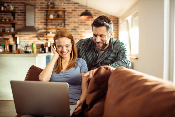 istock Young Couple using a Laptop at home 1217074736