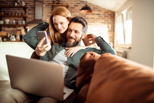 istock Young Couple using a phone at home 1217078241