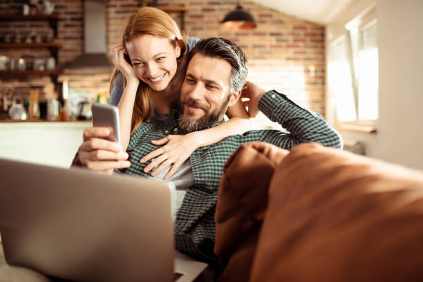 Young Couple using a phone at home