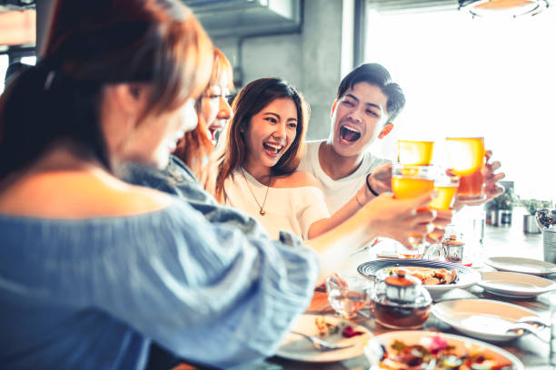 istock happy young friends dining and drinking beer at restaurant 1217082768