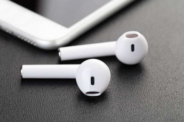 istock Wireless bluetooth headphones with a modern mobile phone on a dark background. The concept of modern technology, gadgets. 1217084025