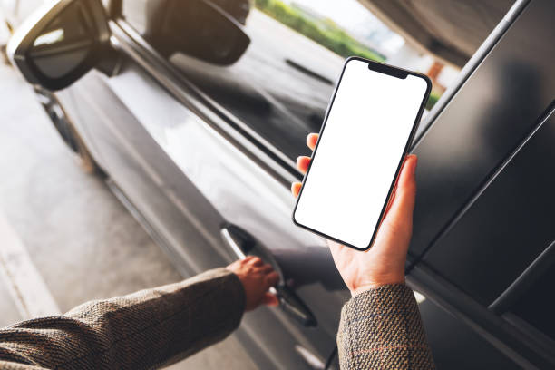 a woman holding and using mobile phone with blank screen while opening the car door