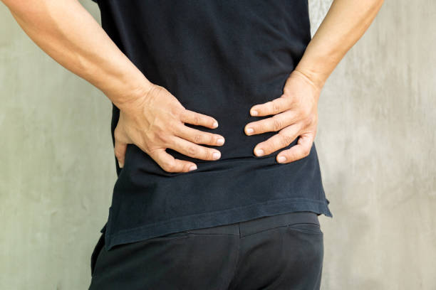 istock Man with back pain isolated on grey background. 1217087467