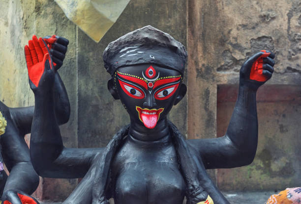 Clay idols of Hindu Goddess Kali in making at Kalighat Patuapara, a traditional place for potters. In the picture, black painted face of an unfinished idol is seen. As there is no proper studio / workshop for most of the artisans, these idols are make directly at roadside.Kali puja is an Indian festival, the most popular religious festival after Durga puja in eastern India, particularly in West Bengal. Photo taken few days before Kali Puja festival in Kolkata on 10/20/2019.