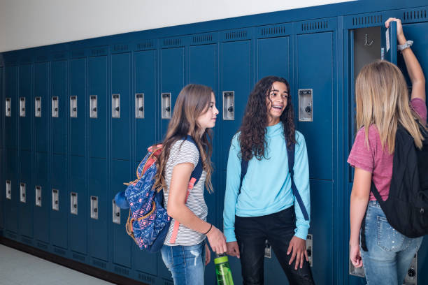 istock Junior High school Students talking and standing by their locker in a school hallway 1217089246