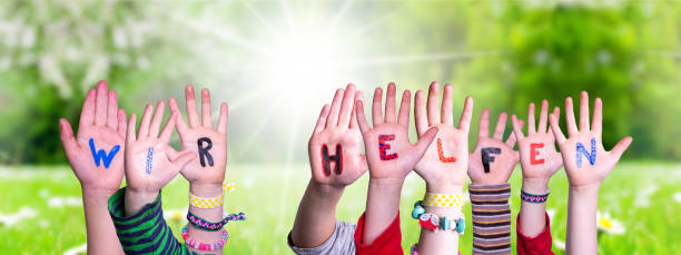 istock Kids Hands Holding Word We Help Means We Help, Grass Meadow 1217089331