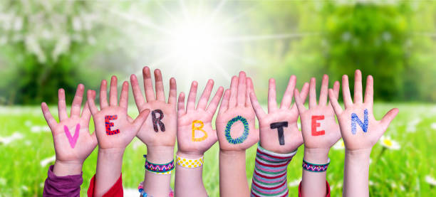 istock Children Hands Building Word Verboten Means Forbidden, Grass Meadow 1217089390
