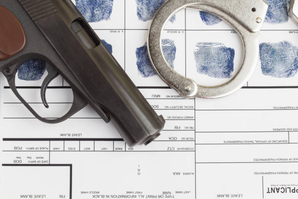 istock Fingerprint card with handcuffs and gun 1217091857