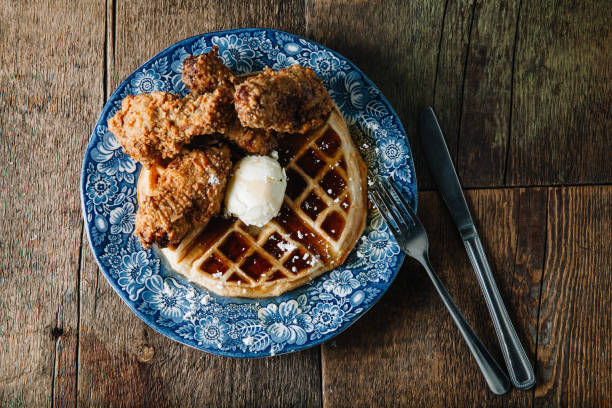 alitas de pollo y gofres servidos con mantequilla y jarabe de mora - waffle chicken fried chicken food fotografías e imágenes de stock