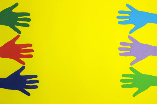 istock Multicolored paper hands on a yellow background. Space for text 1217092830