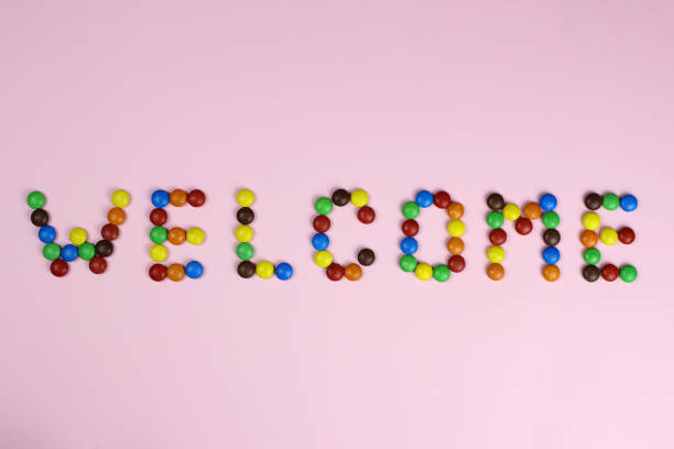 istock The word Welcome from colored candies on a pink background 1217092854