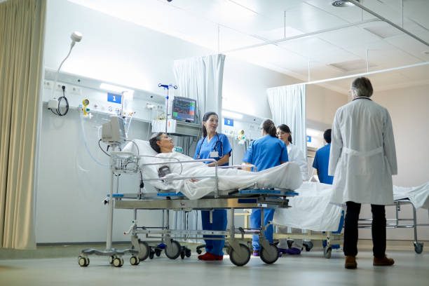 Wide view of the post intensive care unit, doctor talking to a nurse. Hospital health care and medicine. triage stock pictures, royalty-free photos & images