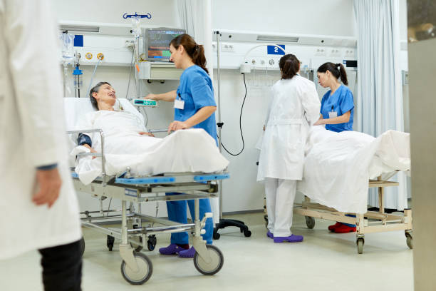 A nurse is talking with a patient lying down in the pos operative zone. Hospital health care and medicine. triage stock pictures, royalty-free photos & images