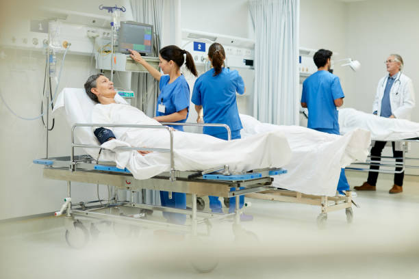 istock Wide view of a post operative area with three gurneys, doctors and nurses. 1217096089