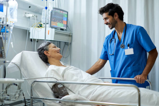 um enfermeiro está ouvindo um paciente na área de recuperação. - hospital patient bed nurse - fotografias e filmes do acervo