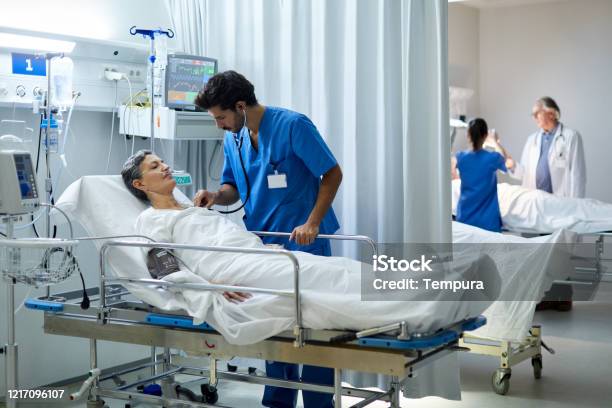 A Male Nurse Is Listening With A Stethoscope The Heart Bit Of A Patient Stock Photo - Download Image Now