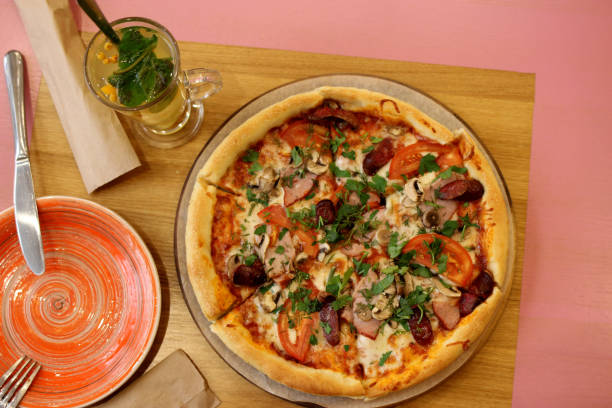 istock pizza with mushrooms, ham, vegetables and herbs on the table. view from the top 1217097887