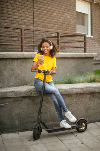 istock Young african woman using the phone on electric scooter. 1217097892