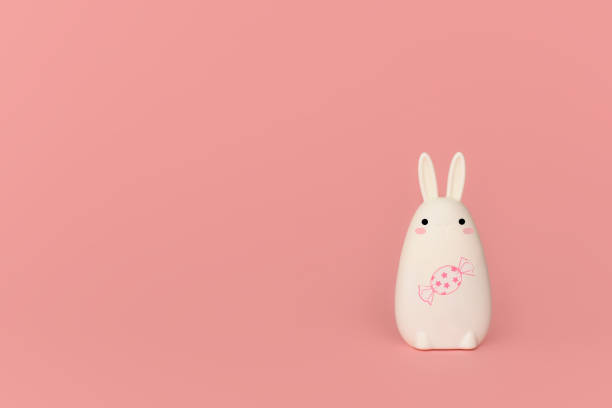 istock Funny white rabbit with a candy on a pink background. Copy space. 1217098149