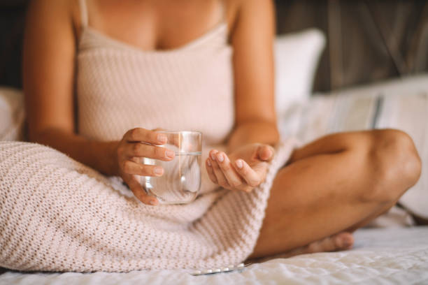 istock Woman taking medicine in bed. 1217098762