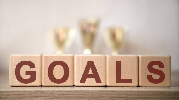 istock GOALS text on wooden cubes with winning cups 1217100146