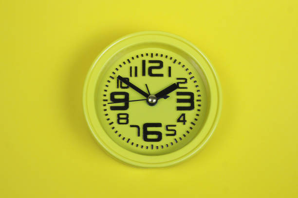 istock yellow alarm clock on yellow background 1217100196