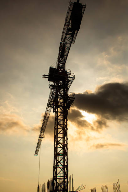 istock Industrial construction cranes and building silhouettes 1217101399