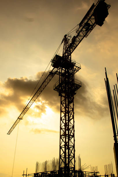 istock Industrial construction cranes and building silhouettes 1217101431