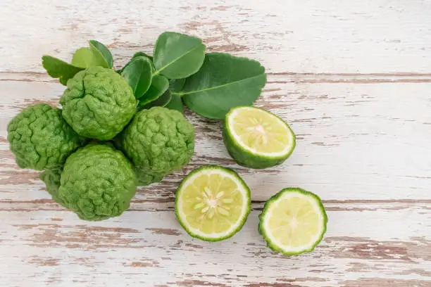 Photo of Fresh bergamot from nature Resting on a wooden plank To be used as a cook and nourish the skin.