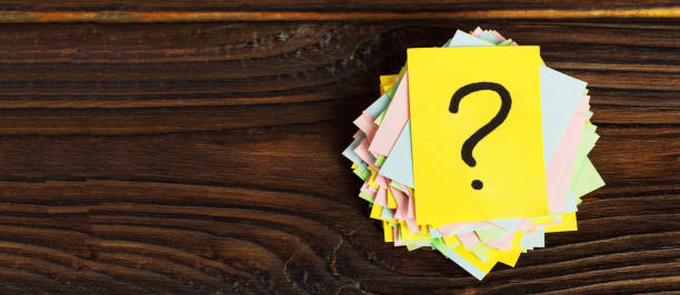 istock Question mark paper heap on wooden table concept for confusion 1217104363