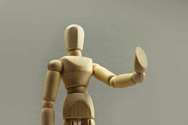 istock Wooden figure making stop sign on a gray background. Concept 1217104480
