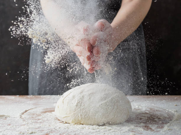 istock Young woman kneading bread dough. 1217109025
