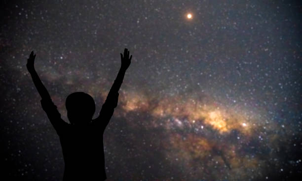 istock Woman enjoying starry night with arms wide open. 1217110299