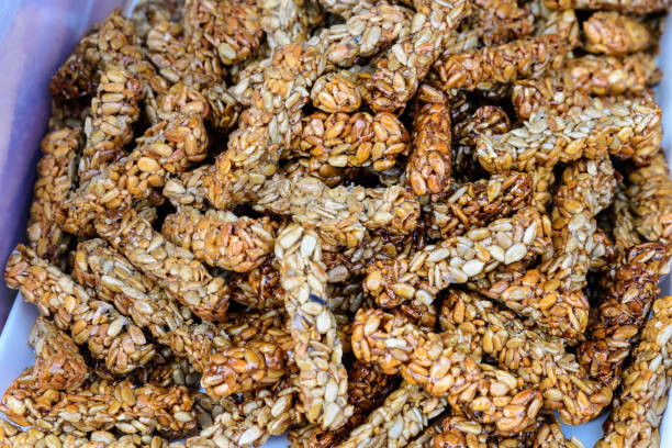 istock Fresh home backed crispy crackers with sun seeds and honey in direct sun light, displayed for sale at a bakery at a street food market festival 1217110513