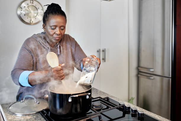 dojrzała afrykańska kobieta gotowanie pap na posiłek w południe - africa african descent cooking african culture zdjęcia i obrazy z banku zdjęć