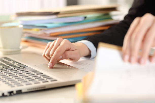 Overworked executive hands checking documents using laptop Close up of overworked executive woman hands checking documents using laptop on a desk at the office entering data stock pictures, royalty-free photos & images