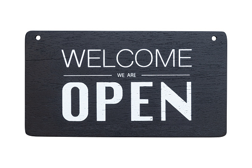 front view of welcome we are open sign on black wooden board isolated on white background