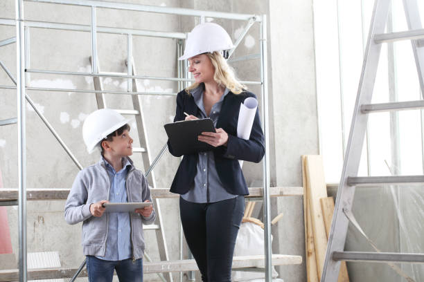 frau innenarchitektin oder architektin mama mit ihrem sohn arbeiten sie zusammen am bau des hauses, innerhalb der baustelle - child building activity construction engineer stock-fotos und bilder