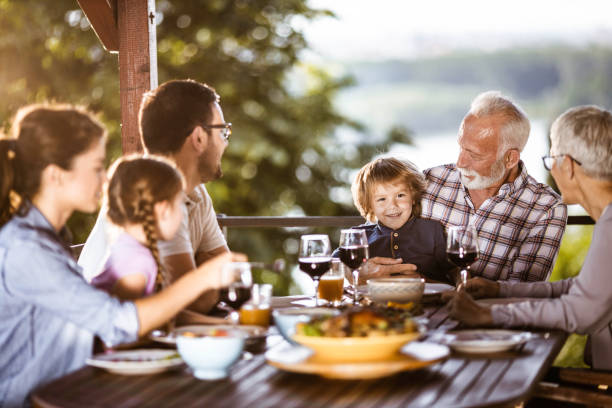 istock Happy extended family talking while having a meal on a balcony. 1217114576