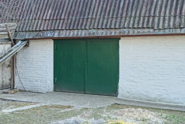 istock facade of a white brick garage with green iron gates 1217115456